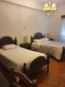 - une chambre avec 2 lits et un lustre dans l'établissement Hotel Novo Dia, à Mêda
