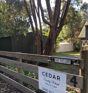 a sign for a garden on a wooden fence at Cedar Country Retreat in Halls Gap