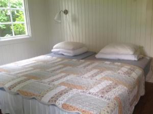 uma cama com duas almofadas e uma colcha em Villa Lavendel em Borgholm