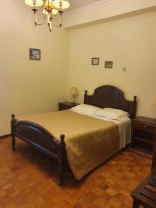 una camera con letto e lampadario a braccio di Hotel Novo Dia a Mêda