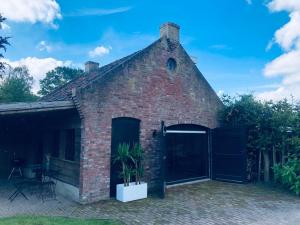 een bakstenen gebouw met een deur en een plant bij Paradise Garage in Hilvarenbeek
