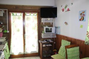 uma sala de estar com duas janelas e uma televisão em Locat dépôt em Bouillante