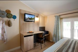 a bedroom with a desk and a tv on a wall at Hotel Porta Nuova in Assisi