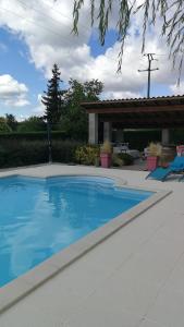 ein Swimmingpool mit blauem Wasser in einem Hof in der Unterkunft Le cheminblanc suite parentale in Saint-Sornin