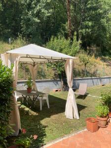 カポローナにあるHome Azzurraの庭の白い傘(テーブルと椅子付)