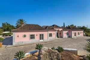 a large pink house with a gravel driveway at Quinta de Santa Margarida - Charm Country House in Tavira