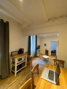 a living room with a table with a laptop on it at La Mettrie in Saint Malo