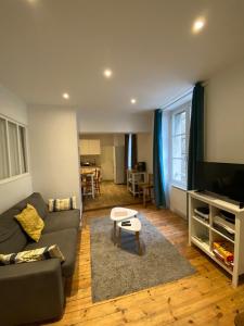 a living room with a couch and a tv at La Mettrie in Saint Malo