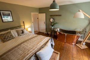 a bedroom with a bed and a bath tub at Sett Cottage in Hayfield