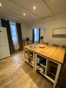 una cocina con mesa de madera y ordenador portátil. en La Mettrie, en Saint-Malo