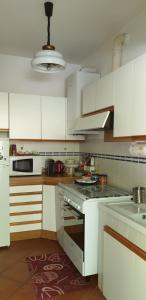 cocina con armarios blancos y fogones en Home Azzurra, en Capolona