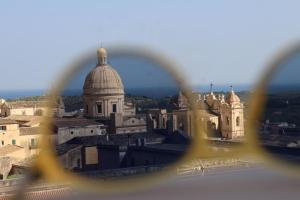 een uitzicht op een kathedraal van achter een bril bij Noto da Quassu' Bed and Breakfast in Noto