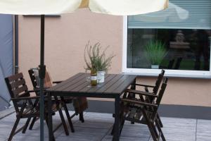 une table en bois avec deux chaises et un parasol dans l'établissement Ferienwohungen Arnold Boppard, à Boppard
