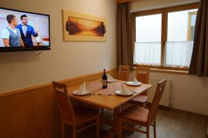 a dining room with a table and a tv on the wall at Haus Dorfblick in Gerlos