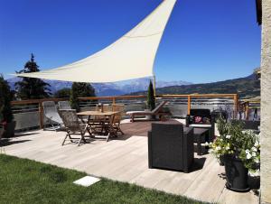 d'une terrasse avec une table et des chaises. dans l'établissement Gîtes Les Garianes, à Saint-Léger-les-Mélèzes