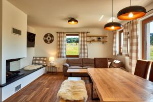 a living room with a table and a couch at Chalupa pod Plešivcem in Abertamy