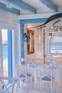 a dining room with white tables and chairs and the ocean at AVANTI Lifestyle Hotel - Only Adults in Corralejo