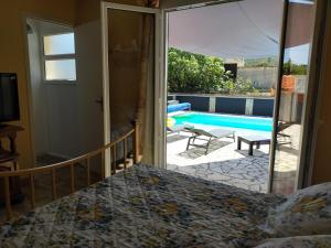 a bedroom with a view of a swimming pool at Gîte climatisé L'OISELLERIE in Castelnou