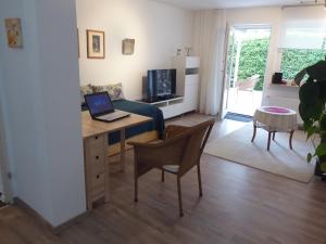 sala de estar con escritorio y ordenador portátil. en Apartment in Maulbronn en Maulbronn