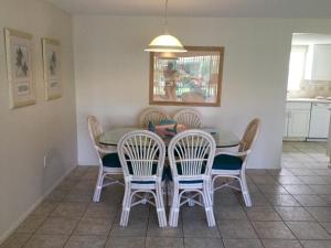 ein Esszimmer mit einem Tisch und 4 Stühlen in der Unterkunft Island House Beach Resort 23 in Point O'Rocks
