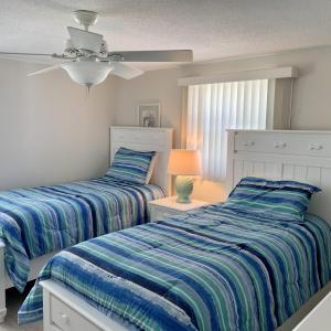 2 nebeneinander sitzende Betten in einem Schlafzimmer in der Unterkunft Island House Beach Resort 23 in Point O'Rocks