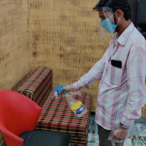 a man wearing a face mask standing next to a couch at Babbar's Den-An Elegant Homestay in Mount Ābu