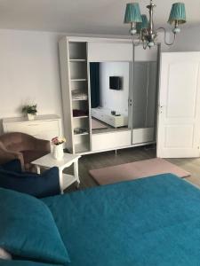 a living room with a blue couch and a large mirror at Tudor Apartment in Brăila