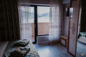 a bedroom with a large window with a view of the water at Montresor Villa in Orşova