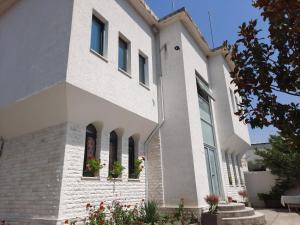 une maison avec des murs et des fenêtres blancs dans l'établissement Guesthouse "PELIVANI", à Berat