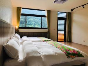 uma cama grande num quarto com uma janela grande em 南庄漫晨旅店Nanzhuang Manchen B&B em Nanzhuang