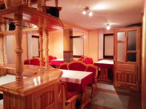 a dining room with tables and red chairs at Guesthouse Mali Raj in Jahorina