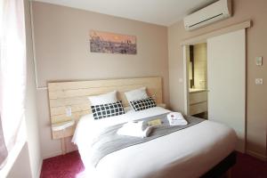 Un pat sau paturi într-o cameră la Hôtel La Couronne