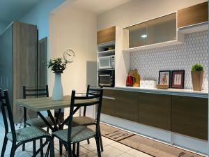 a kitchen with a table and chairs and a counter at B & A Suites Inn Hotel - Quarto Luxo Safira in Anápolis