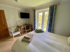 een slaapkamer met een bed, een raam en een bureau bij Millbrook in Penistone