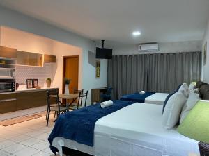 阿纳波利斯B & A Suites Inn Hotel - Quarto Luxo Safira的一间有两张床和厨房的酒店房间