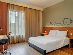 um quarto de hotel com uma cama e uma janela em ibis Styles SP Centro em São Paulo