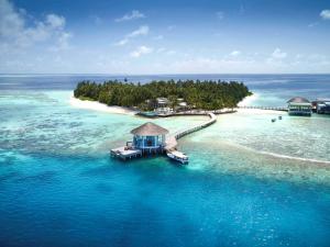 an island in the ocean with a house on it at Raffles Maldives Meradhoo in Gaafu Alifu Atoll