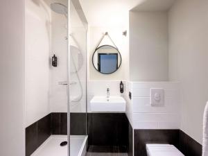a bathroom with a toilet, sink and mirror at ibis La Rochelle Vieux Port in La Rochelle