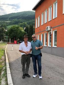 two men are standing in front of a building at Becar Pyramid Rooms in Visoko