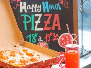 a pizza in a box next to a happy hour pizza sign at ibis budget Nice Californie Lenval in Nice