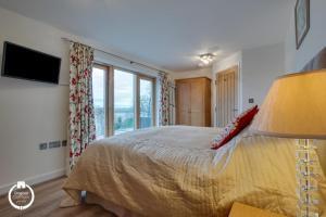 a bedroom with a bed and a large window at The Old Stables Aberdyfi apartment 3 in Aberdyfi