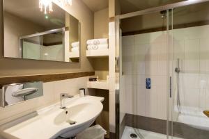 bagno con lavandino e doccia di Hotel Royal Victoria, by R Collection Hotels a Varenna