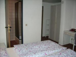 1 dormitorio con 1 cama y puerta al baño en Gästehaus Hochrhönblick en Schönau an der Brend