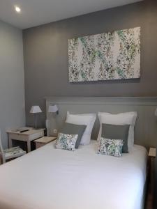 a bedroom with a large white bed with two pillows at Les Embruns in Trouville-sur-Mer