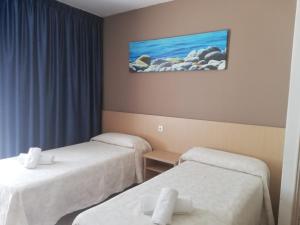 une chambre d'hôtel avec 2 lits et un tableau mural dans l'établissement Apartamentos Orvay, à Sant Antoni de Portmany