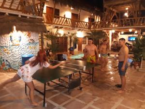 a group of people standing around a ping pong table at Weekendhostal in Montañita