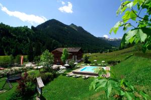 ein Resort mit einem Pool und einem Berg in der Unterkunft Landhaus St. Georg in Saalbach-Hinterglemm