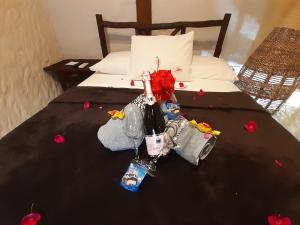 Una cama con una botella de vino y flores. en Weekendhostal, en Montañita