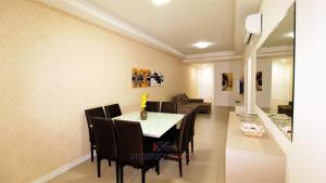 comedor y sala de estar con mesa y sillas en 1068 - Apartamento com vista para o mar, en Bombinhas