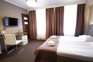 a hotel room with two beds and a television at Hotel Kolorowa in Karpacz
